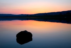 Une fois le soleil disparu, le jeux des couleurs débutent sur l'eau calme du lac des Taillères