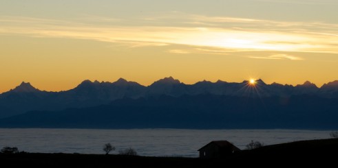 Photo d'un joli lever de soleil sur les alpes depuis le sommet du Creux-du-Van.
